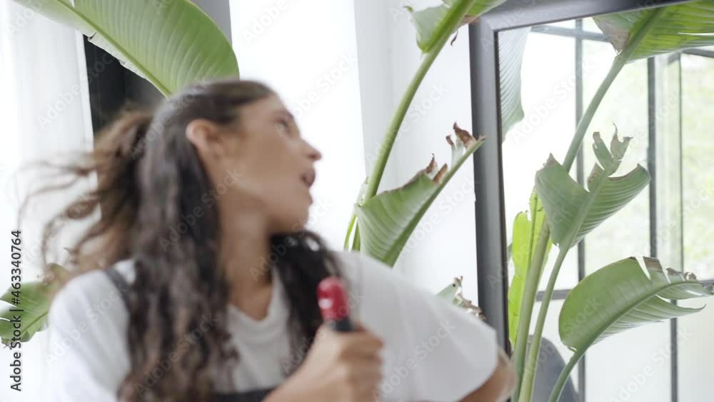 Funny crazy girl dancing while cleaning house. Cheerful cute latina woman sings to broom. Real people. Slow motion. Funny crazy girl dancing while cleaning house. Cheerful cute latina woman sings to broom. Real people. Slow motion.