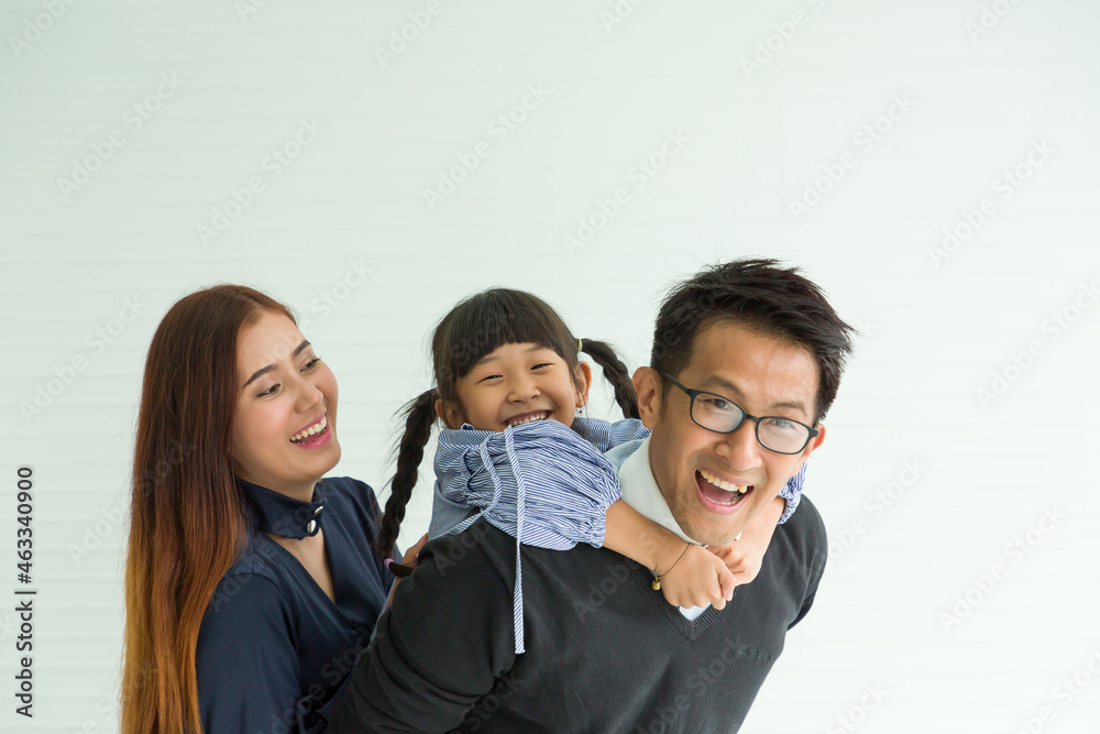 Happy Asian family having fun with home. Asian father playing and carrying little daughter on back at home with happy and smile Happy Asian family having fun with home. Asian father playing and carrying little daughter on back at home with happy and smile