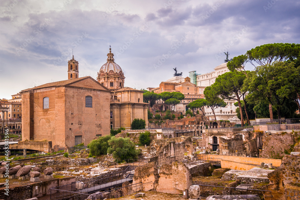 Magnificent old buildings in Rome behind ancient remains, Italy
