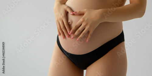 Image of pregnant woman touching her big belly. Close up. Motherhood, pregnancy, people and expectation concept. Pregnant woman expecting baby . Beauty woman with on white background © looking2thesky