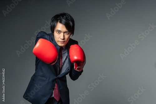 ボクシンググローブをつけてパンチをするビジネスマン photo