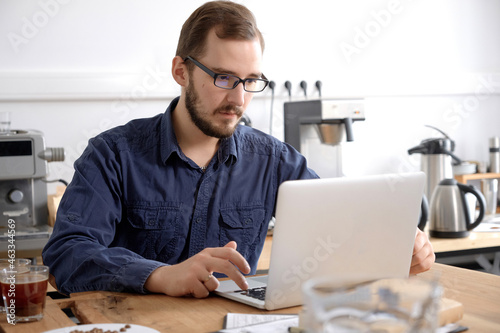 Man using laptop at coffee bar