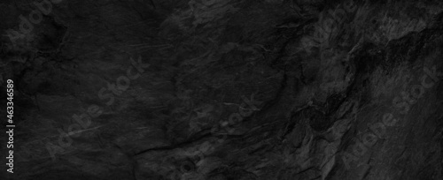 Panorama dark gray stone background with copy space. Black grunge banner with rock texture.