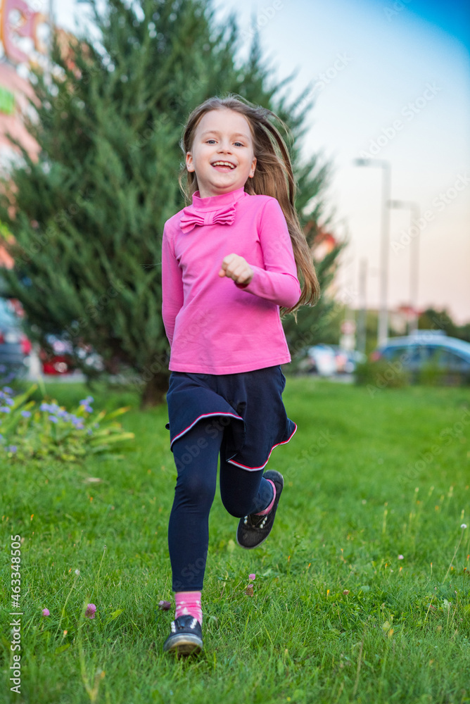 Beautiful little girl in a pink blouse is having fun on the city street. Beautiful little girl in a pink blouse is having fun on the city street.