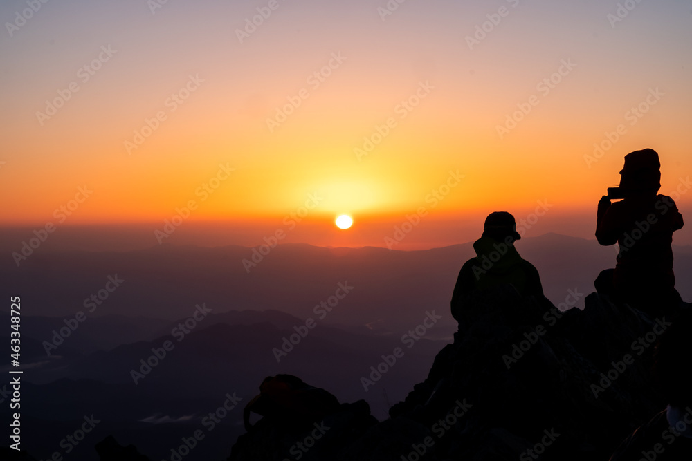日の出と登山者