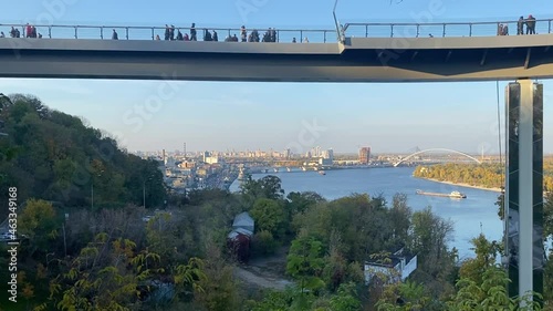 Pedestrian and bicycle bridge across Vladimirsky descent is metal three-span beam bridge 216 meters long, in central city of Kiev, capital of Ukraine by Dnieper River. Scenic cityscape of Kyiv town. photo