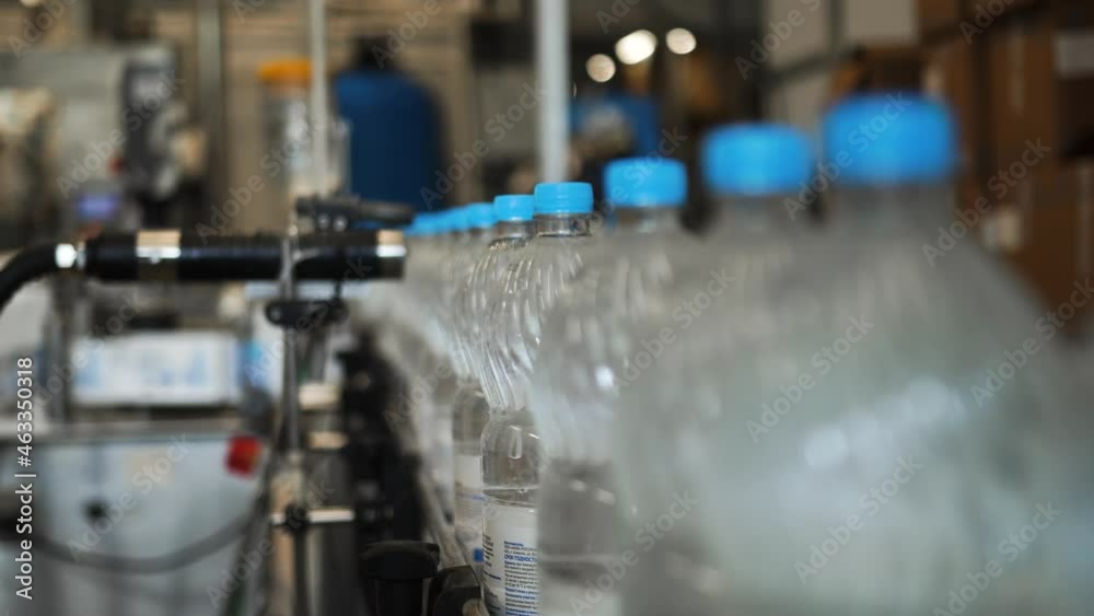 Production, bottling plant for drinking carbonated water. Automated line, sticker, stamping of labels, emblems with roller of the manufacturer's brand on plastic bottles, containers with spring water. Production, bottling plant for drinking carbonated water. Automated line, sticker, stamping of labels, emblems with roller of the manufacturer's brand on plastic bottles, containers with spring water.