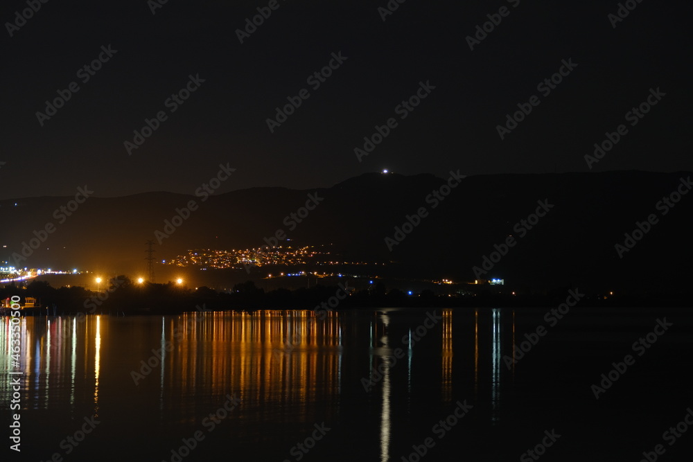 City lights photo, a village in night and city lights reflection on iznik lake during evening.