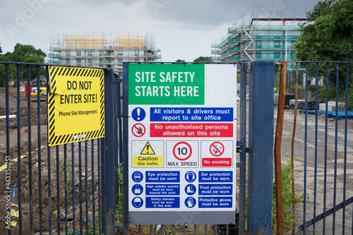Construction site health and safety message rules sign board signage on fence boundary photo