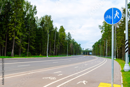 empty road, for bicycles and pedestrians with a road sign and new asphalt, clear summer day, traffic