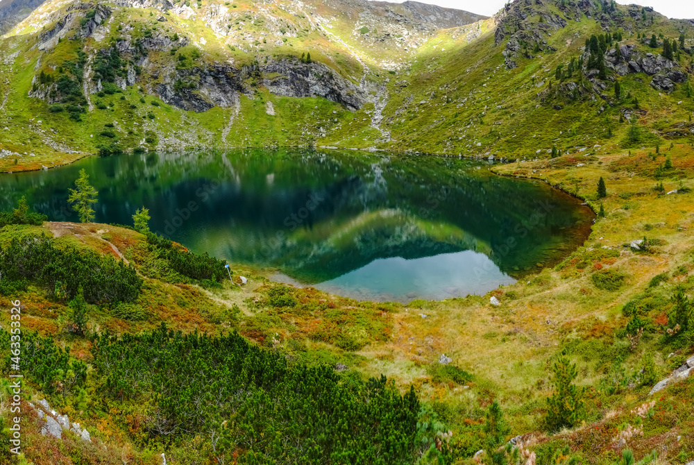 reflections from the mountains in a clear cold mountain lake in austria panorama reflections from the mountains in a clear cold mountain lake in austria panorama