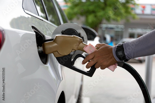 Closeup of people pumping gasoline fuel in car at gas station. Petrol or gasoline being pumped into a motor vehicle car. photo