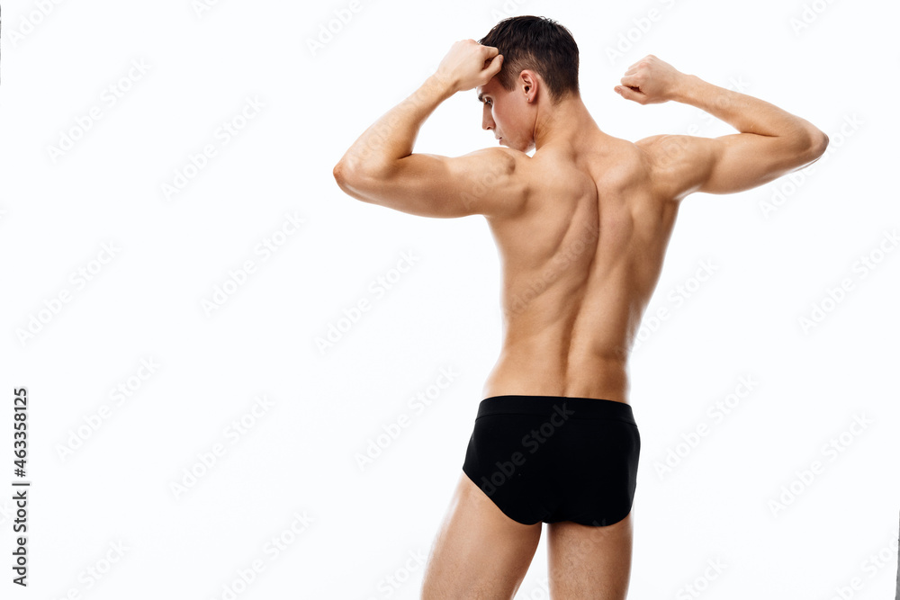 man athlete in shorts holding hands behind head back view fitness bodybuilder man athlete in shorts holding hands behind head back view fitness bodybuilder