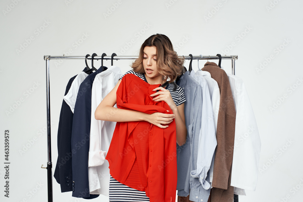 pretty woman Shopaholic choosing clothes shopping in store light background