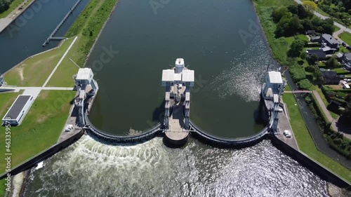 High altitude aerial drone view of modern water channel controller controlled at both sides by a gate or lock these gates commonly control levels and flow rates in rivers and canals 4k footage photo