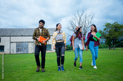 Happy Asian Group of students talking and holding notebooks outdoors and smiling together