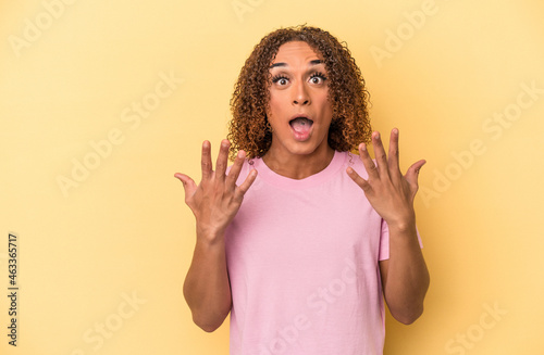 Young latin transsexual woman isolated on yellow background showing number ten with hands.