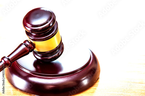 Wooden judge's hammer with a metal ring and soundboard, on a white background with lighting and space for copying.