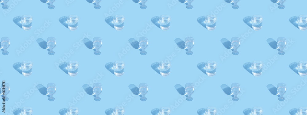 Glasses with water and shadow pattern on blue background banner format Glasses with water and shadow pattern on blue background banner format