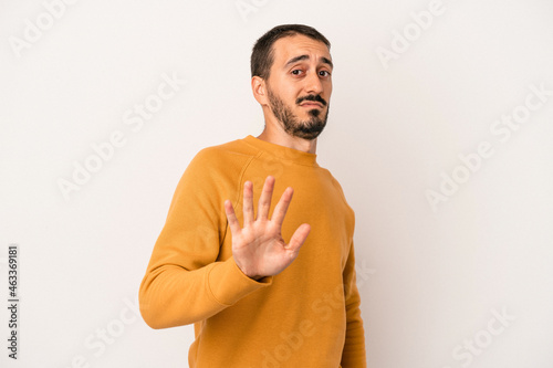 Young caucasian man isolated on white background being shocked due to an imminent danger