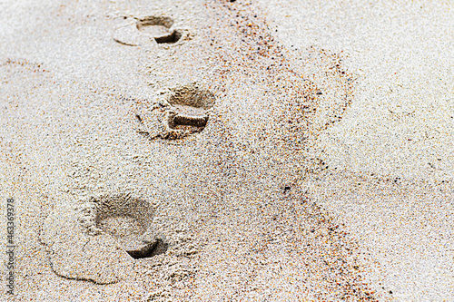 Traces of shoe prints on the sand of the beach, a minimalistic beach scene.