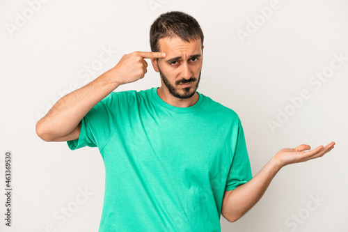 Young caucasian man isolated on white background showing a disappointment gesture with forefinger. © Asier