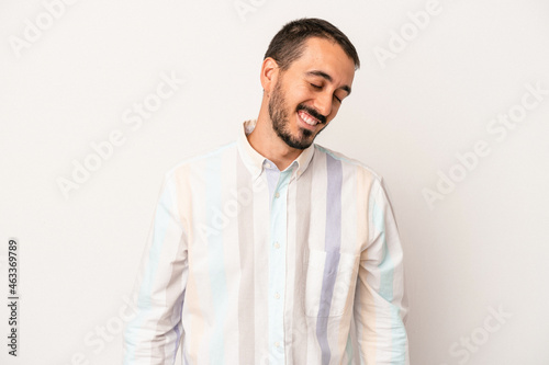 Young caucasian man isolated on white background laughs and closes eyes, feels relaxed and happy.