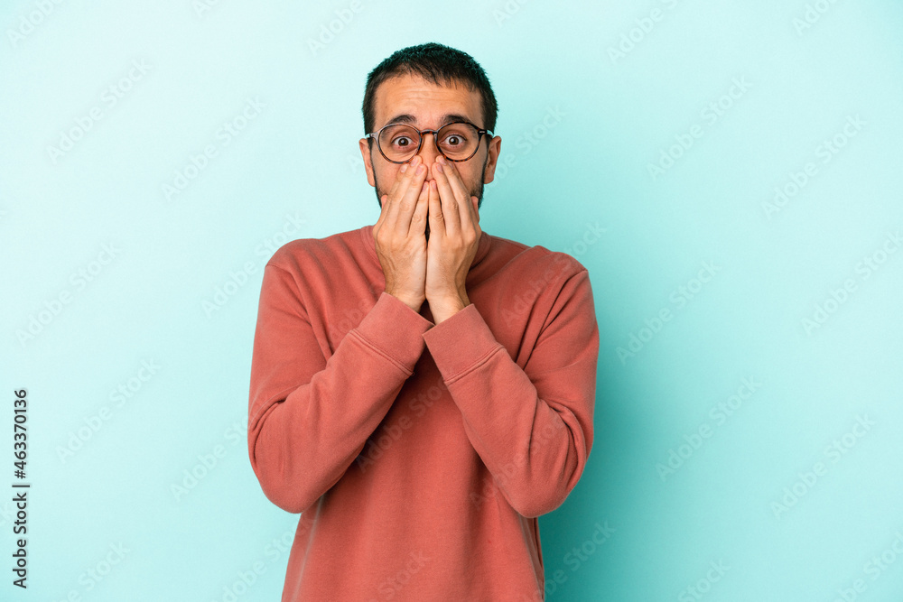 Young caucasian man isolated on blue background laughing about something, covering mouth with hands. Young caucasian man isolated on blue background laughing about something, covering mouth with hands.