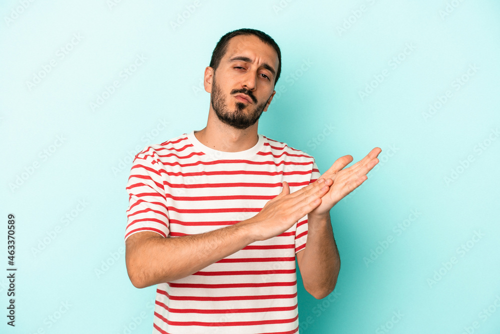 Young caucasian man isolated on blue background feeling energetic and comfortable, rubbing hands confident. Young caucasian man isolated on blue background feeling energetic and comfortable, rubbing hands confident.