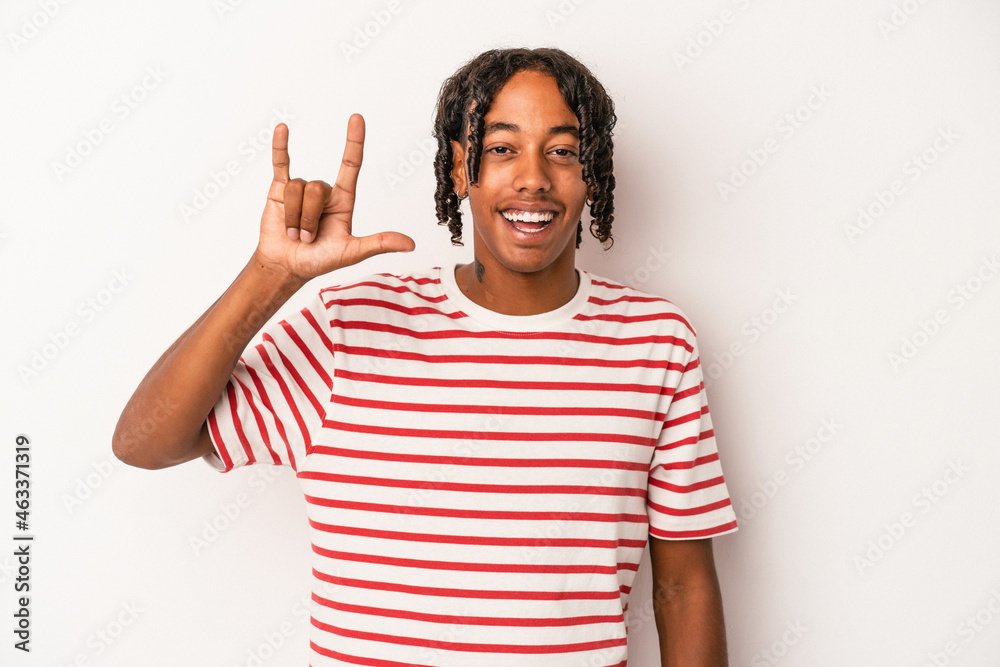 Young african american man isolated on white background showing a horns gesture as a revolution concept. Young african american man isolated on white background showing a horns gesture as a revolution concept.