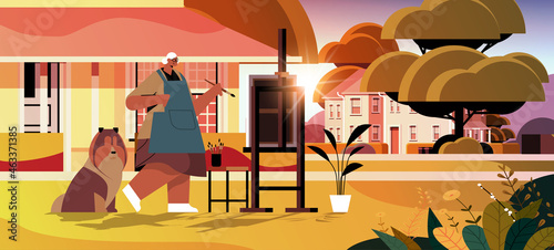senior woman artist with dog painting picture on backyard lawn creative hobby concept full length