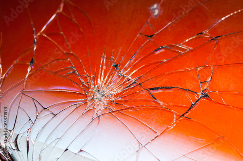 Close-up of a broken smartphone glass, red background