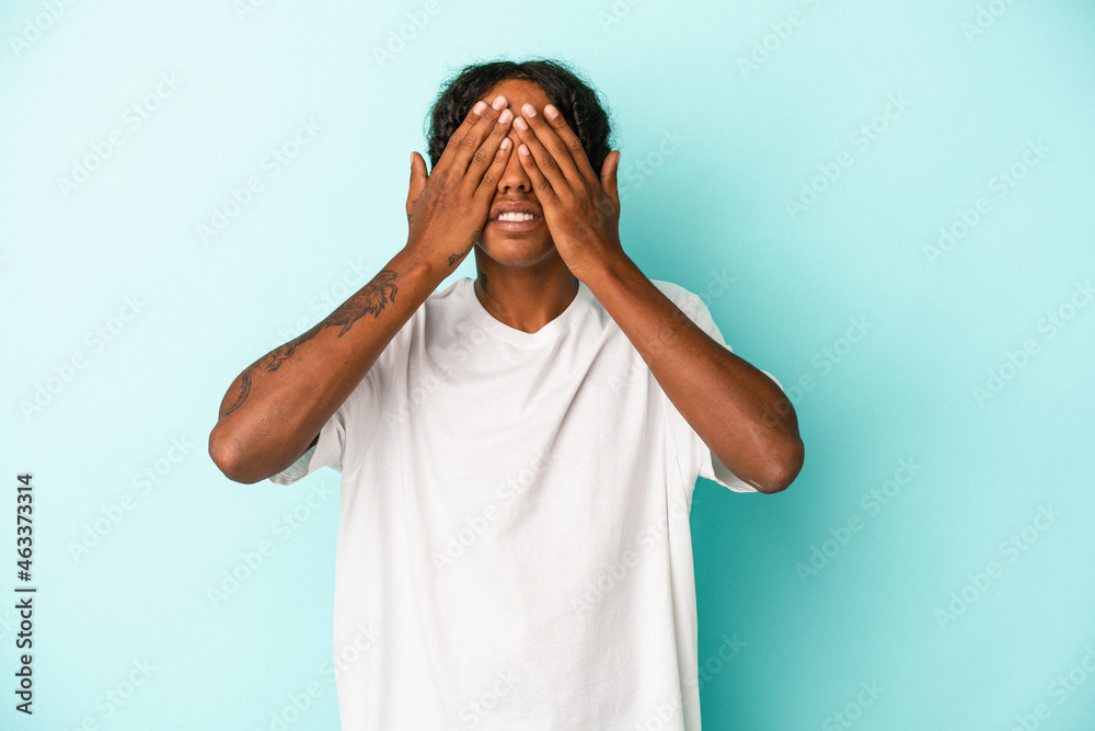Young african american man isolated on blue background afraid covering eyes with hands. Young african american man isolated on blue background afraid covering eyes with hands.