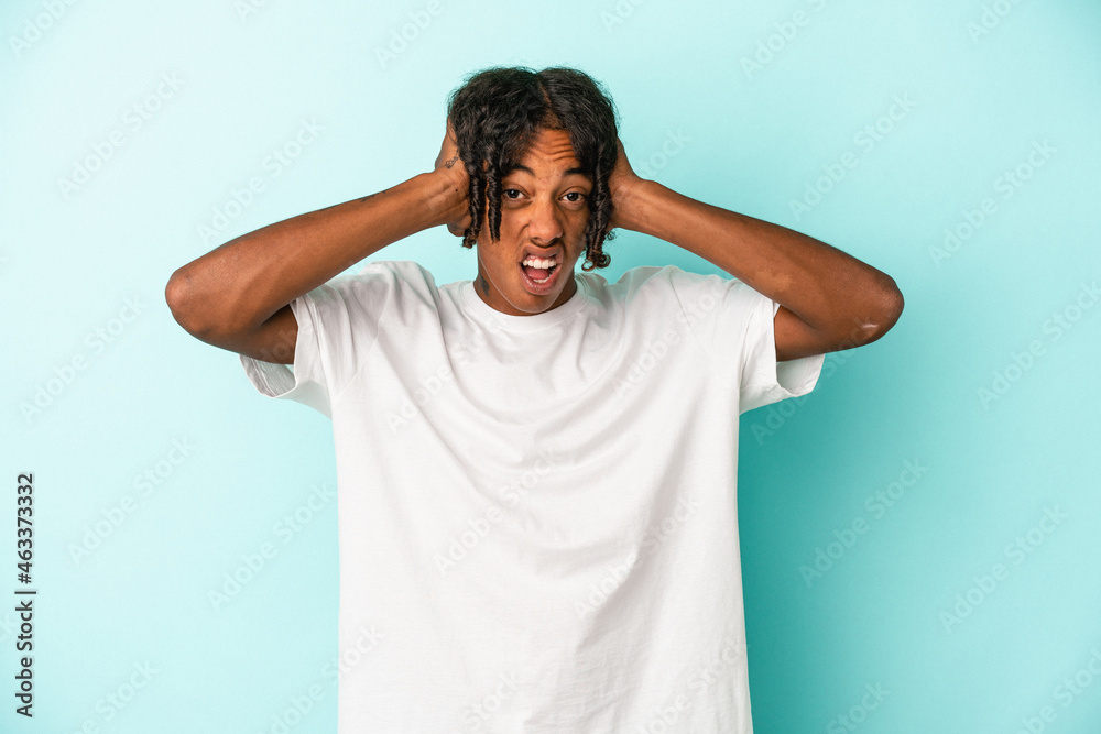Young african american man isolated on blue background screaming, very excited, passionate, satisfied with something. Young african american man isolated on blue background screaming, very excited, passionate, satisfied with something.