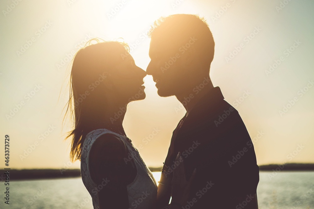 Romantic couple kissing outside at sunset - Boyfriend and girlfriend in love enjoying intimacy together - Love concept - obrazy, fototapety, plakaty 