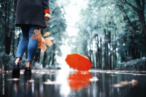 autumn landscape in the park girl with a red umbrella / concept autumn weather raining, a young woman under an umbrella