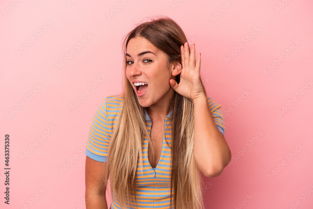 Young Russian woman isolated on pink background blink at the camera through fingers, embarrassed covering face. Young Russian woman isolated on pink background blink at the camera through fingers, embarrassed covering face.