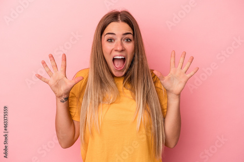 Young Russian woman isolated on pink background relaxed and happy laughing, neck stretched showing teeth.