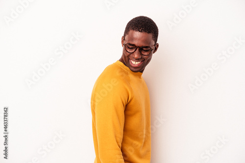 Young African American man isolated on white background looks aside smiling, cheerful and pleasant.