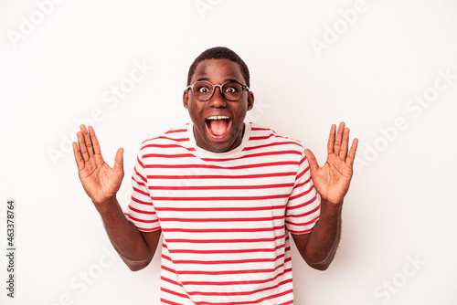 Young African American man isolated on white background receiving a pleasant surprise, excited and raising hands.