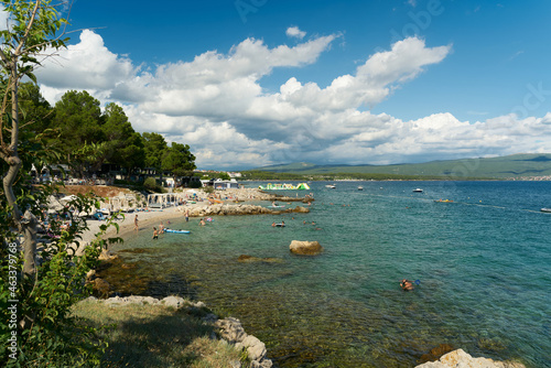 Fototapeta Naklejka Na Ścianę i Meble -  Holidaymakers bathing in a bay at a campsite near the old town of Krk in Croatia