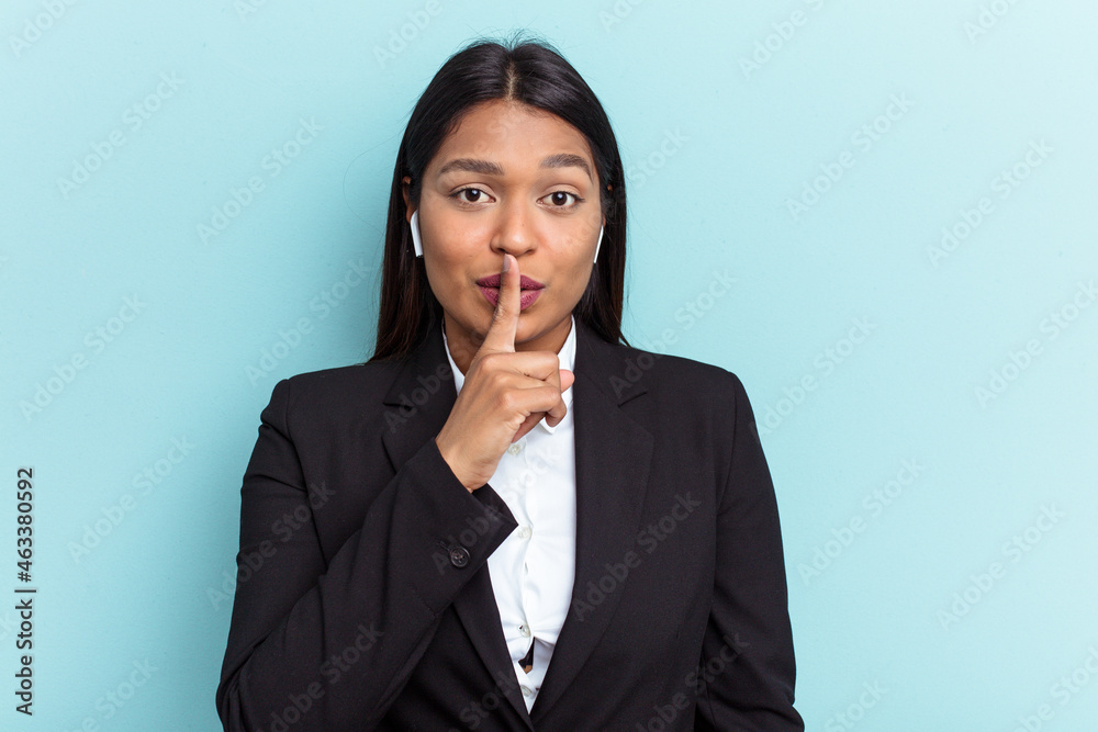 Young Venezuelan business woman isolated on blue background keeping a secret or asking for silence. Young Venezuelan business woman isolated on blue background keeping a secret or asking for silence.