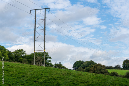 overhead high voltage cables and natural wooden pylon providing power to a rural environment