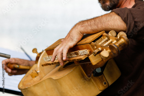 A man plays an old musical mechanical string instrument hurdy-gurdy photo