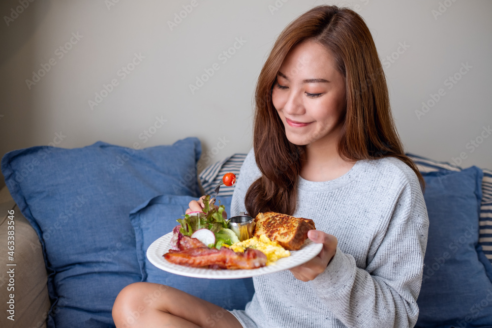 A young woman eating American breakfast at home