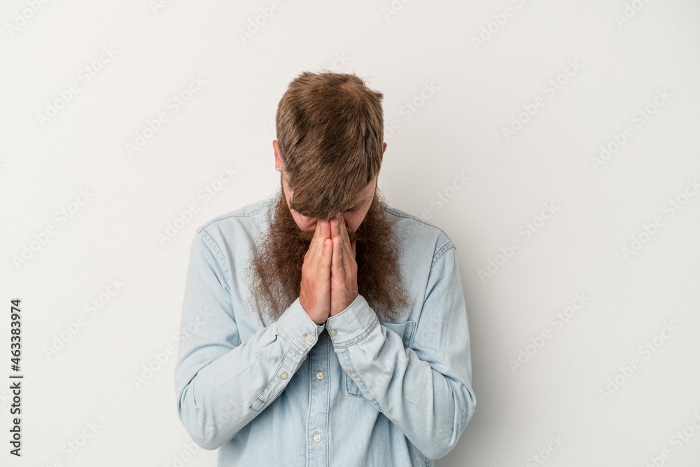 Young caucasian ginger man with long beard isolated on white background praying, showing devotion, religious person looking for divine inspiration. Young caucasian ginger man with long beard isolated on white background praying, showing devotion, religious person looking for divine inspiration.