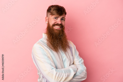 Young caucasian ginger man with long beard isolated on pink background who feels confident, crossing arms with determination.