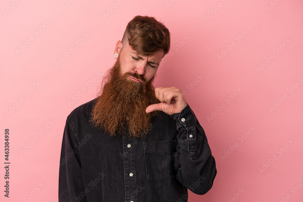 Young caucasian ginger man with long beard isolated on pink background showing a dislike gesture, thumbs down. Disagreement concept. Young caucasian ginger man with long beard isolated on pink background showing a dislike gesture, thumbs down. Disagreement concept.