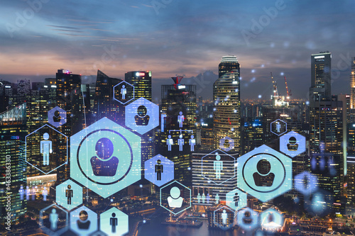 Glowing Social media icons on night panoramic city view of Singapore, Asia. The concept of networking and establishing new connections between people in businesses. Double exposure.