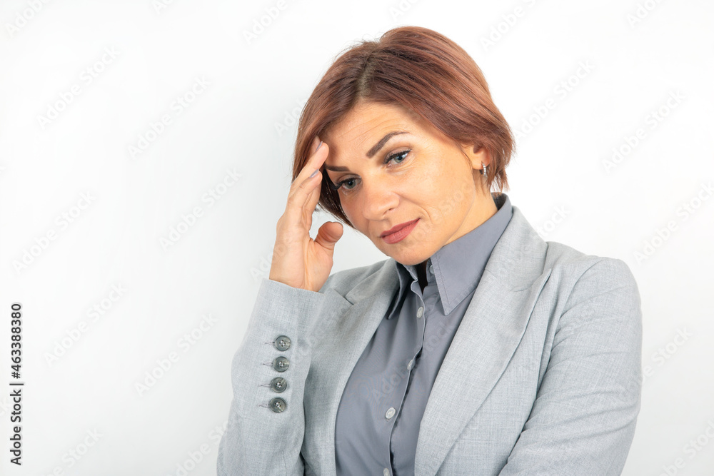 Beautiful young business girl in a suit thinks over her project on a white background Beautiful young business girl in a suit thinks over her project on a white background
